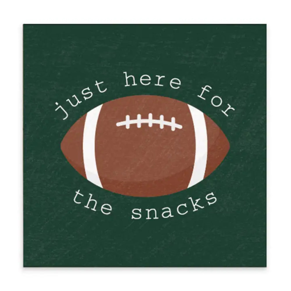 A decorative football plaque with text "just here for the snacks" with a green background on it.