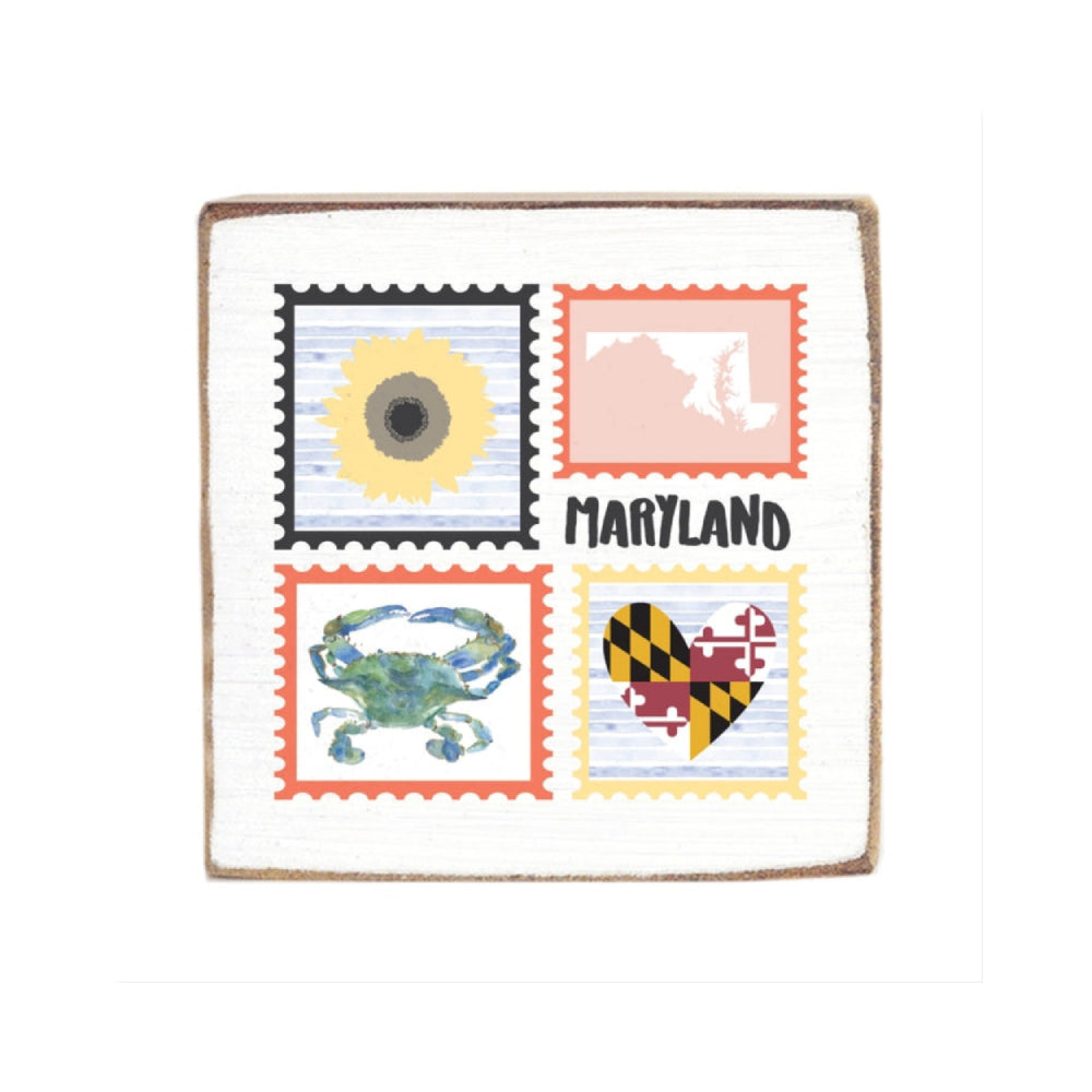 A white wood decorative square block sign with postage stamp designs featuring a sun, state outline, crab, and Maryland flag, with 'Maryland' text.