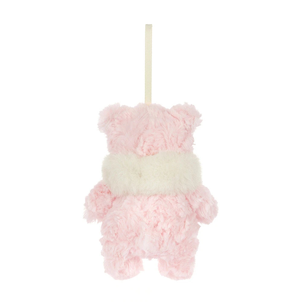 The back of a small pink plush hanging bear ornament in soft pink and cream white faux fur, suspended by a cream ribbon on a plain white background.