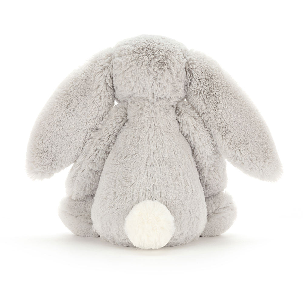 A photo of the back of silver grey bunny with long ears and a soft belly, sitting upright.