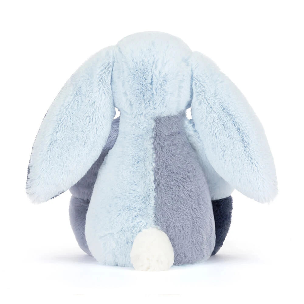 A photo of the back of a colorful blue striped bunny in differant shades of blue on a white backround 
