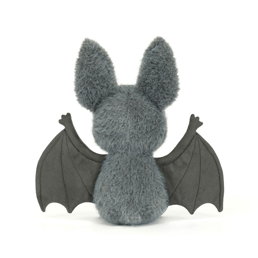 The back of a plush toy bat with gray fur and black wings on a white background.