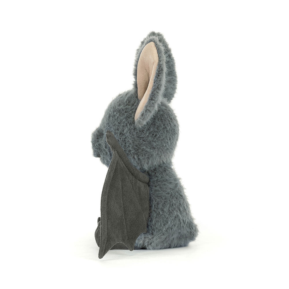 Side of a plush toy bat with gray fur on a white background.