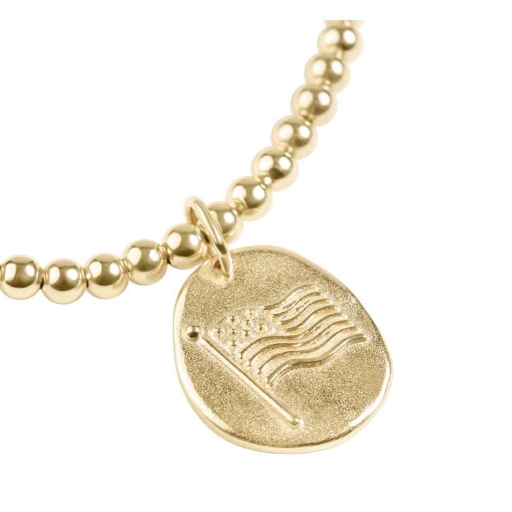Gold beaded bracelet with a round pendant featuring an American flag design on a white background.