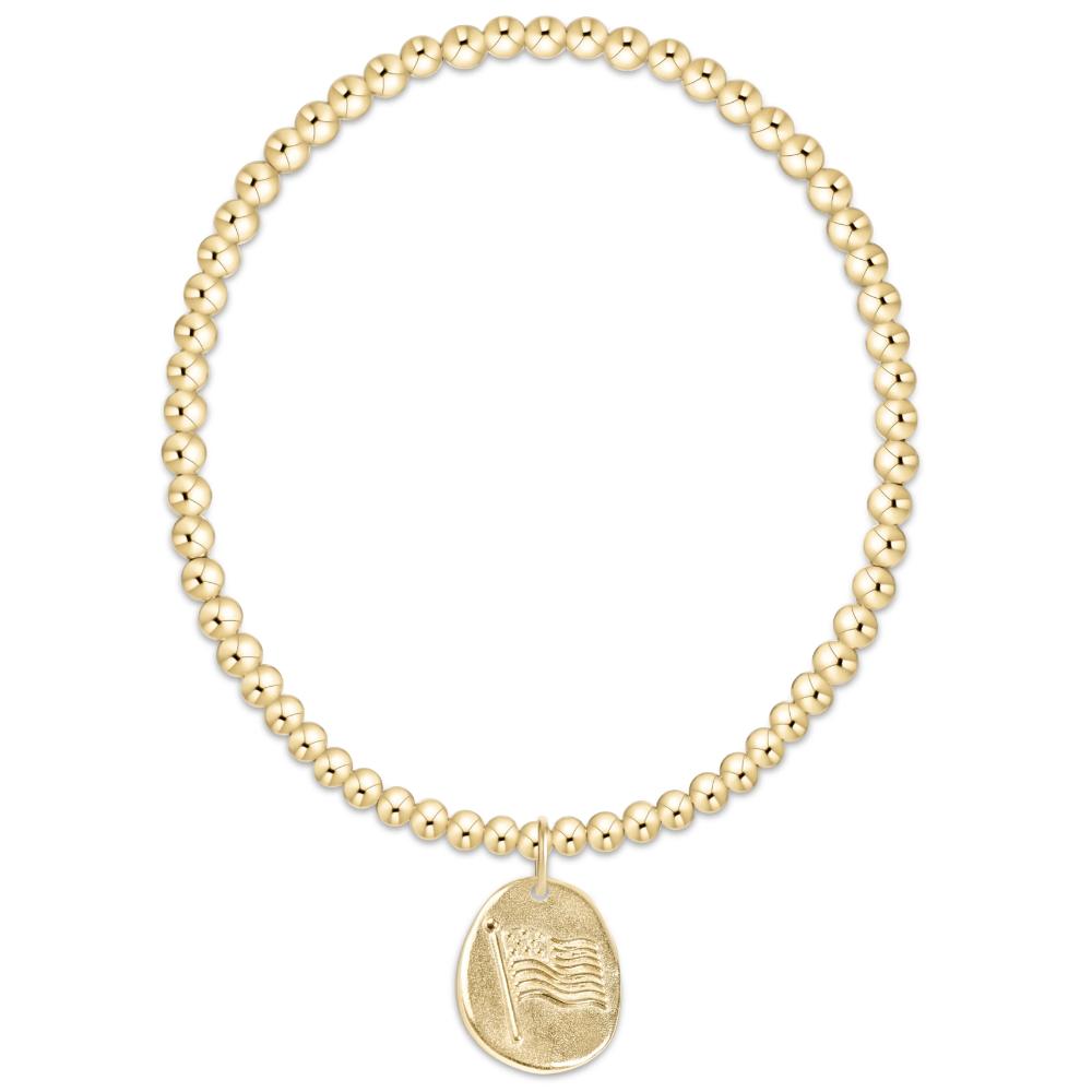 Gold beaded bracelet with a pendant on a white background