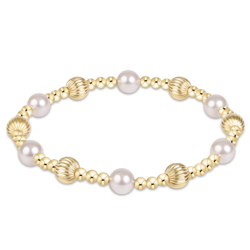 A gold beaded stretch bracelet featuring alternating smooth white pearls and textured gold spacer beads, shown on a plain white background.