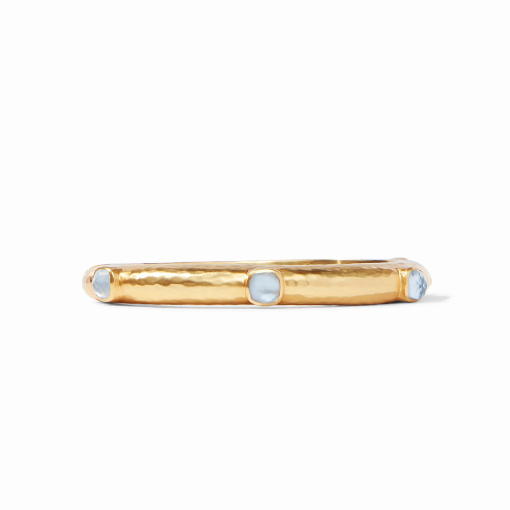 Gold bracelet with three circular blue stones on a white background