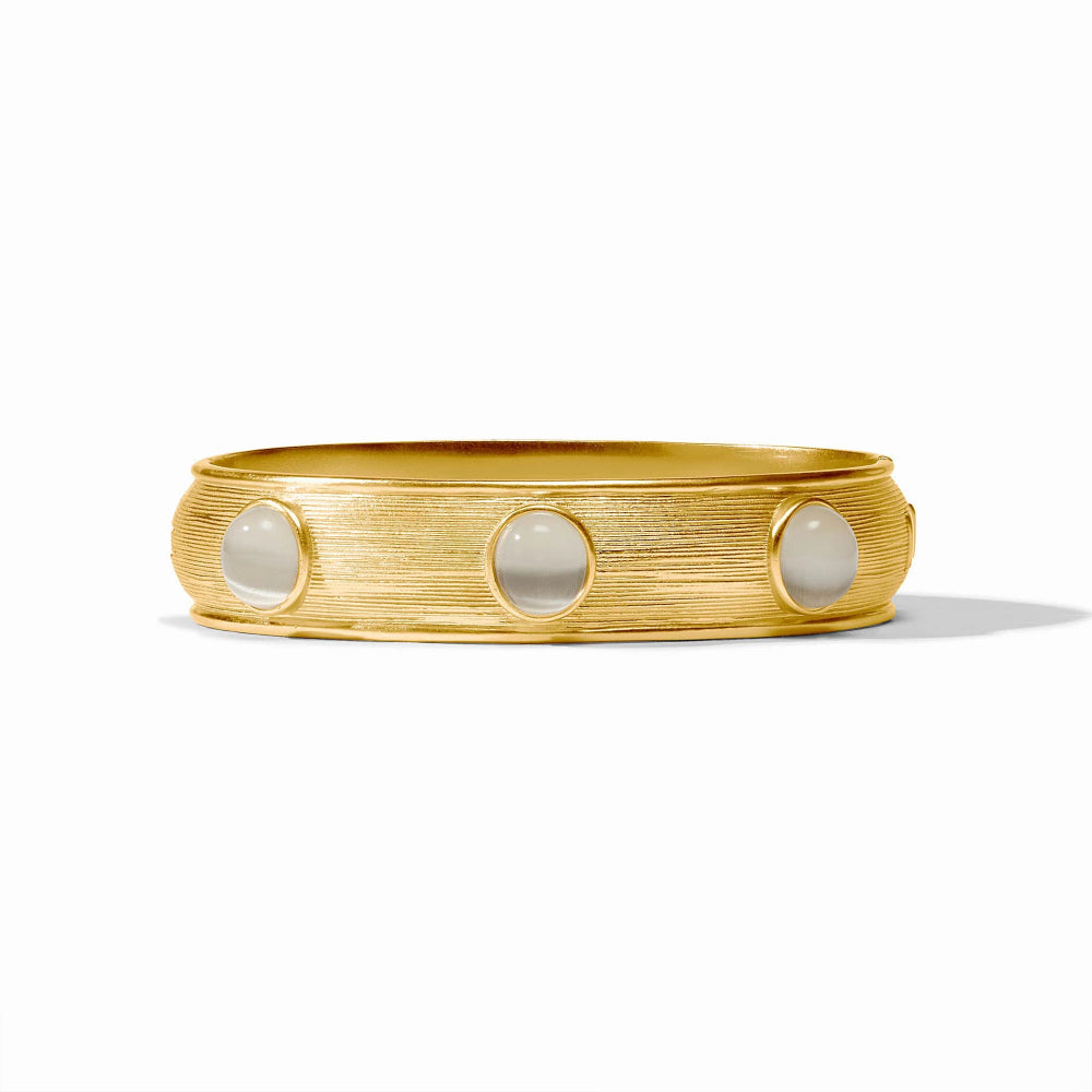 A textured gold bangle bracelet featuring three evenly spaced, round off-white stone inlays, photographed on a clean white background.