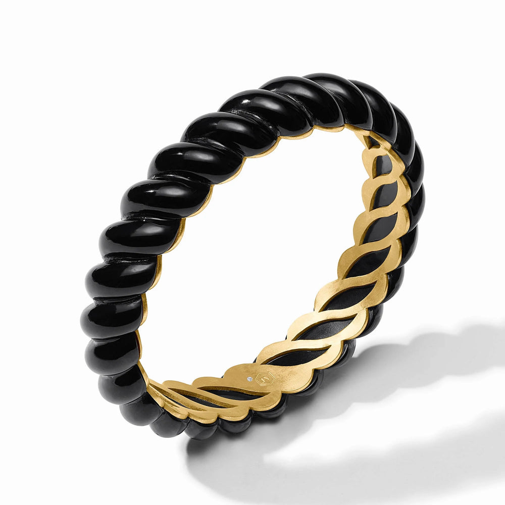 Black beaded ring with gold braided design on a white background