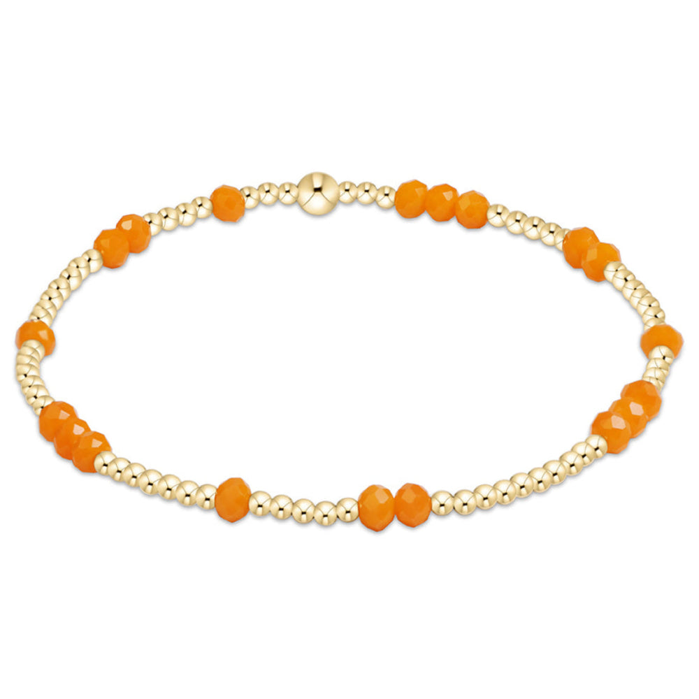 A beaded stretch bracelet featuring alternating strands of matte orange round beads and metallic gold-toned round beads, displayed on a clean white background.