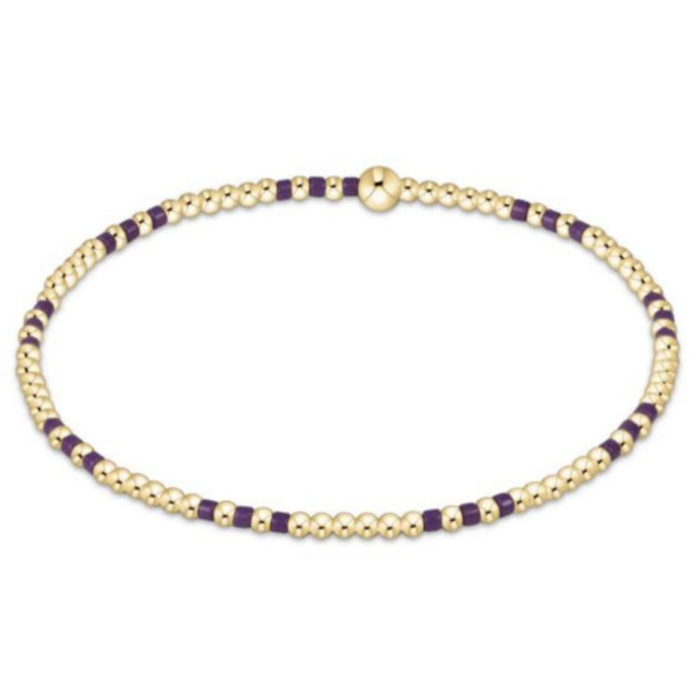 Gold and purple beaded bracelet on a white background