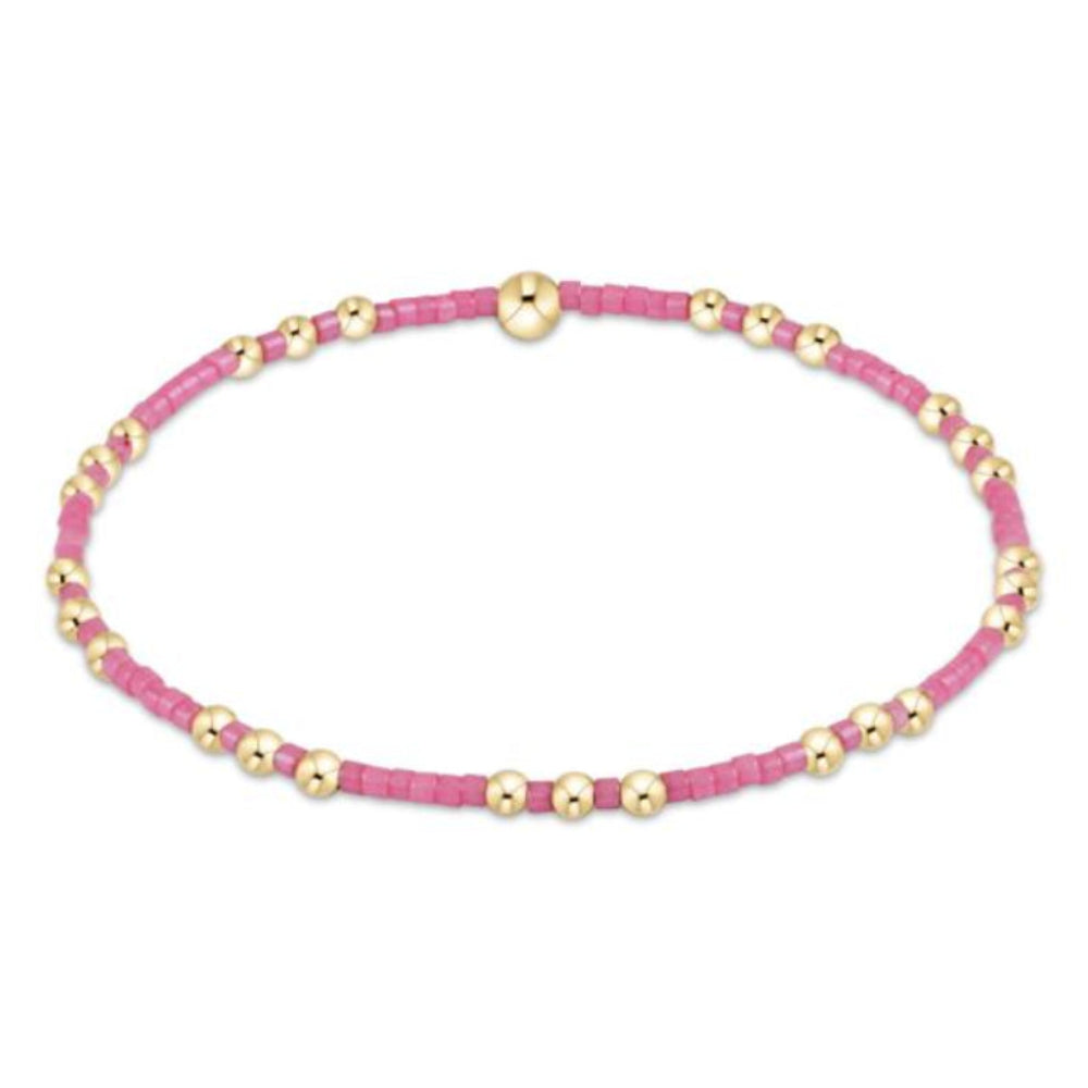 Bracelet with pink beads and gold accents on a white background