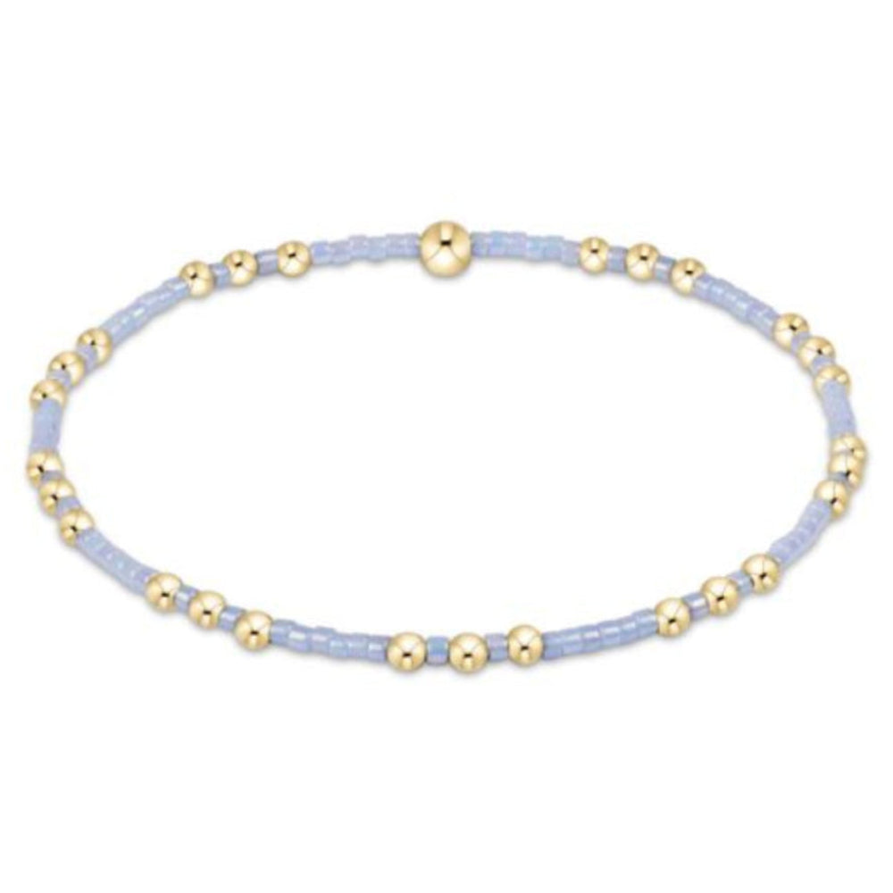 Bracelet with gold and light blue beads on a white background
