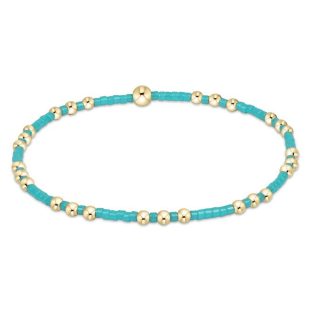 Turquoise and gold beaded bracelet on a white background