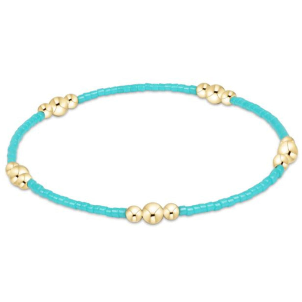 Turquoise bracelet with gold beads on a white background
