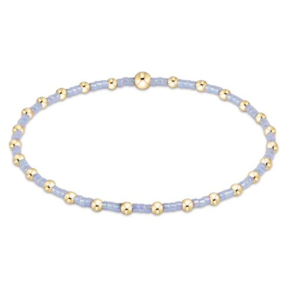 Bracelet with gold and light blue beads on a white background