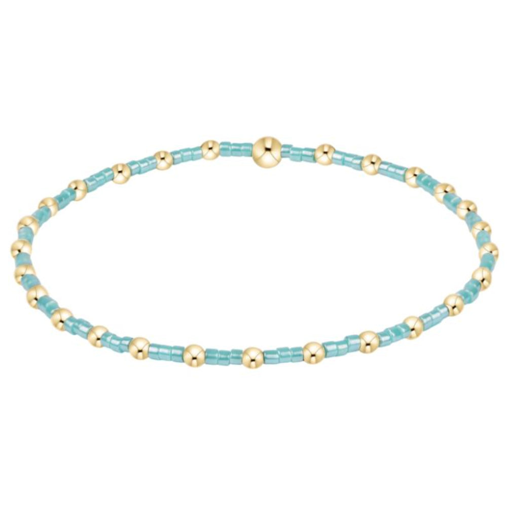 Beaded bracelet with alternating turquoise and gold beads on a white background