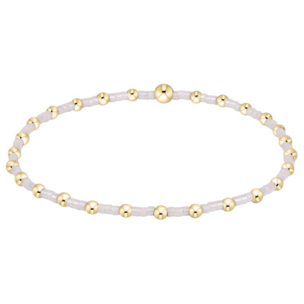 Bracelet with gold and white beads on a white background
