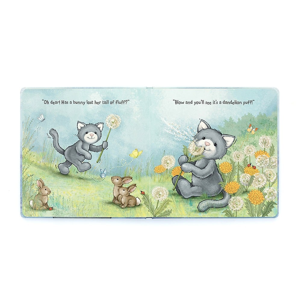 A opened page in the book 'When I Wonder' with two grey cats with grass,flowers and bunnies against a blue sky on a white backround.