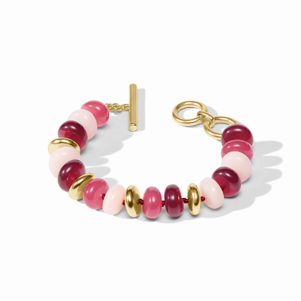 Bracelet with pink and red beads and gold accents on a white background