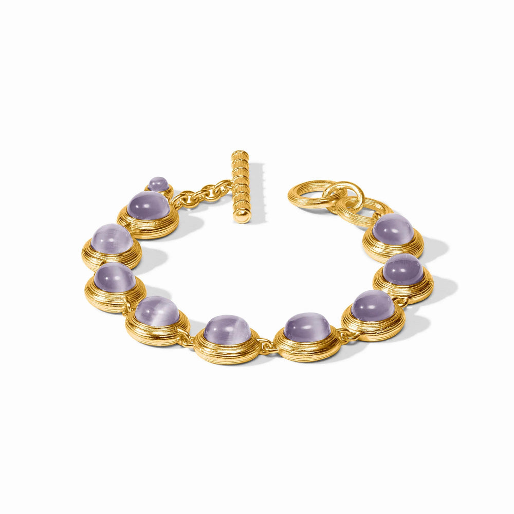 A gold bracelet featuring eight oval light purple cabochon gemstones in gold bezel settings, with a textured gold toggle clasp, shown on a clean white background.