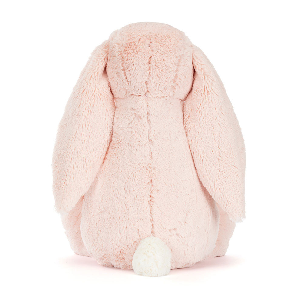 A photo of the back of a big sized pink plush bunny with  floral-patterned ears on a white background.