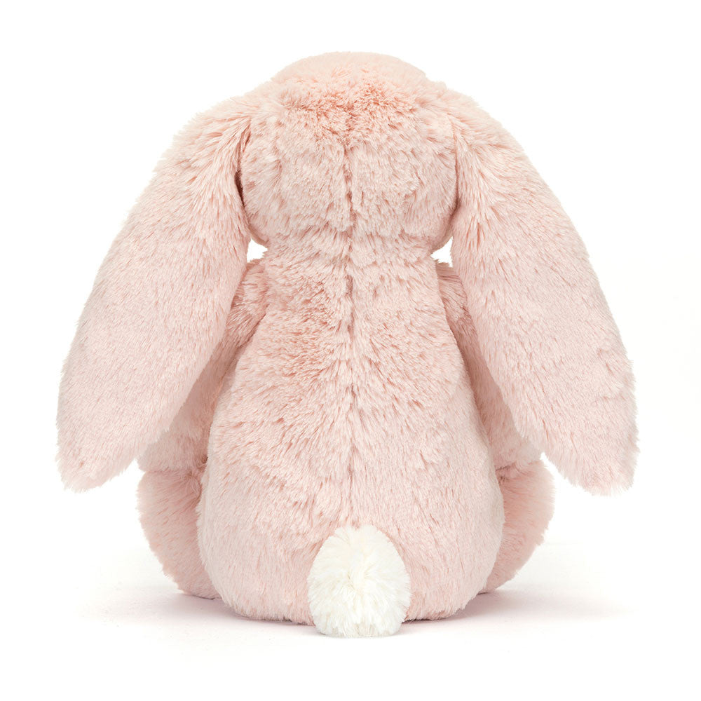 A photo of the back of a medium/original sized pink plush bunny with  floral-patterned ears on a white background.