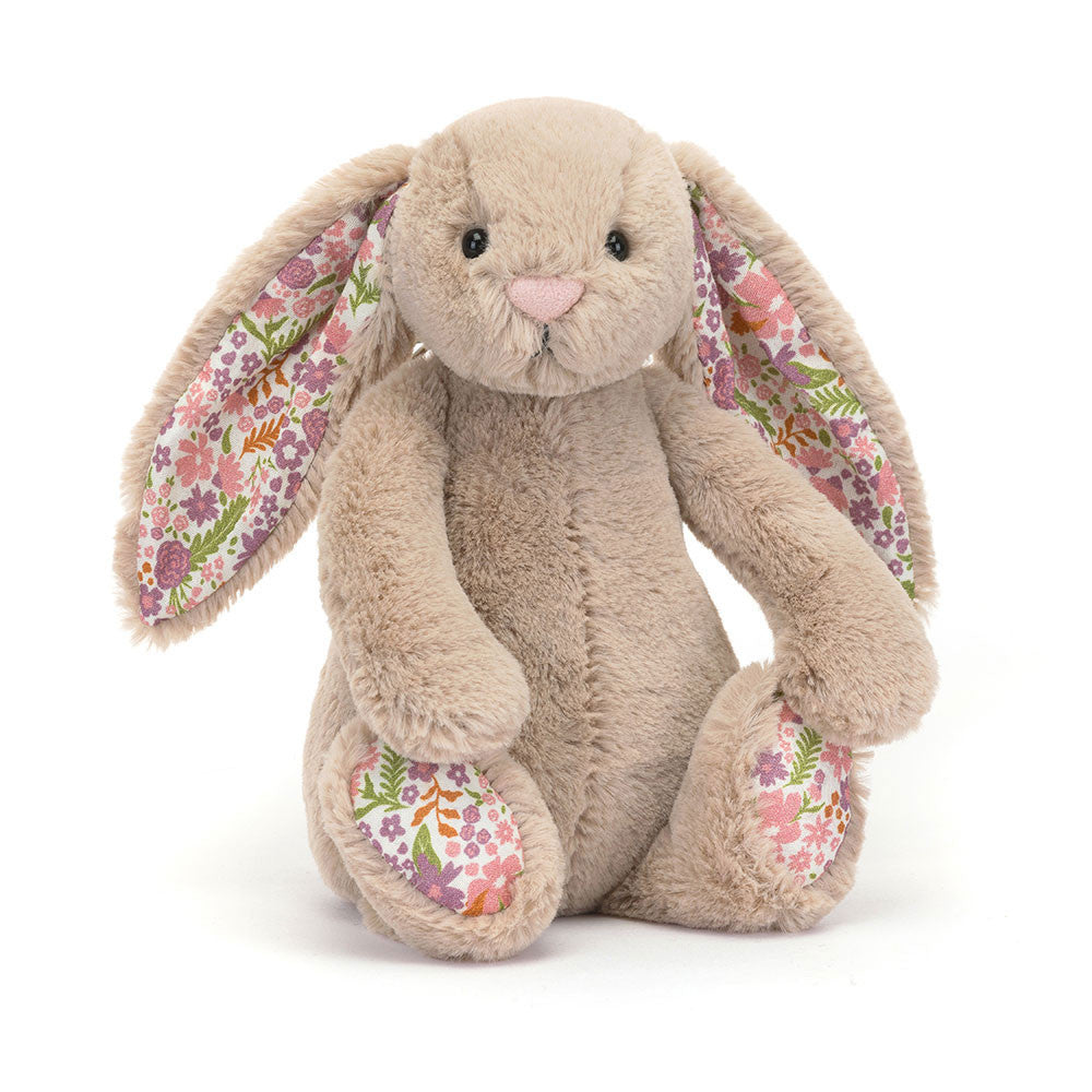 A angled photo of the little sized plush bunny toy with floral ears and feet on a white background.