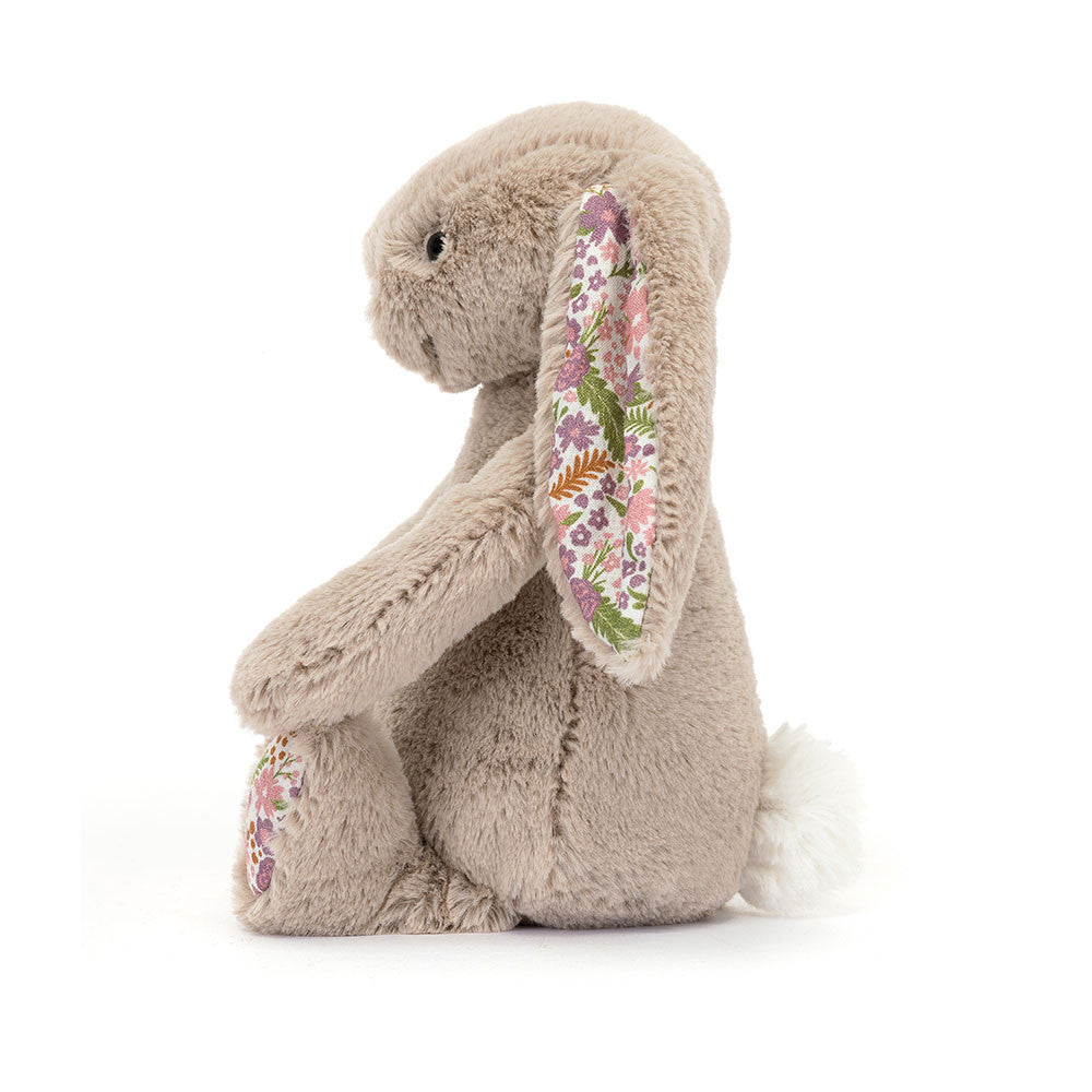 A photo of the side of the little sized plush bunny toy with floral ears and feet on a white background.