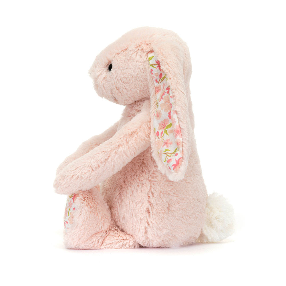 A side view of a Little sized pink plush bunny with  floral-patterned ears on a white background.