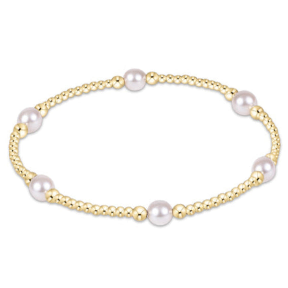 A delicate gold chain bracelet featuring five evenly spaced white freshwater pearls, displayed on a clean white background.