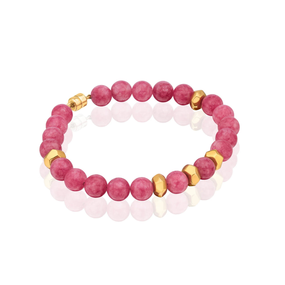 A beaded bracelet featuring round pinkish-red gemstone beads and faceted gold spacer beads, displayed on a clean white background with a soft reflection.