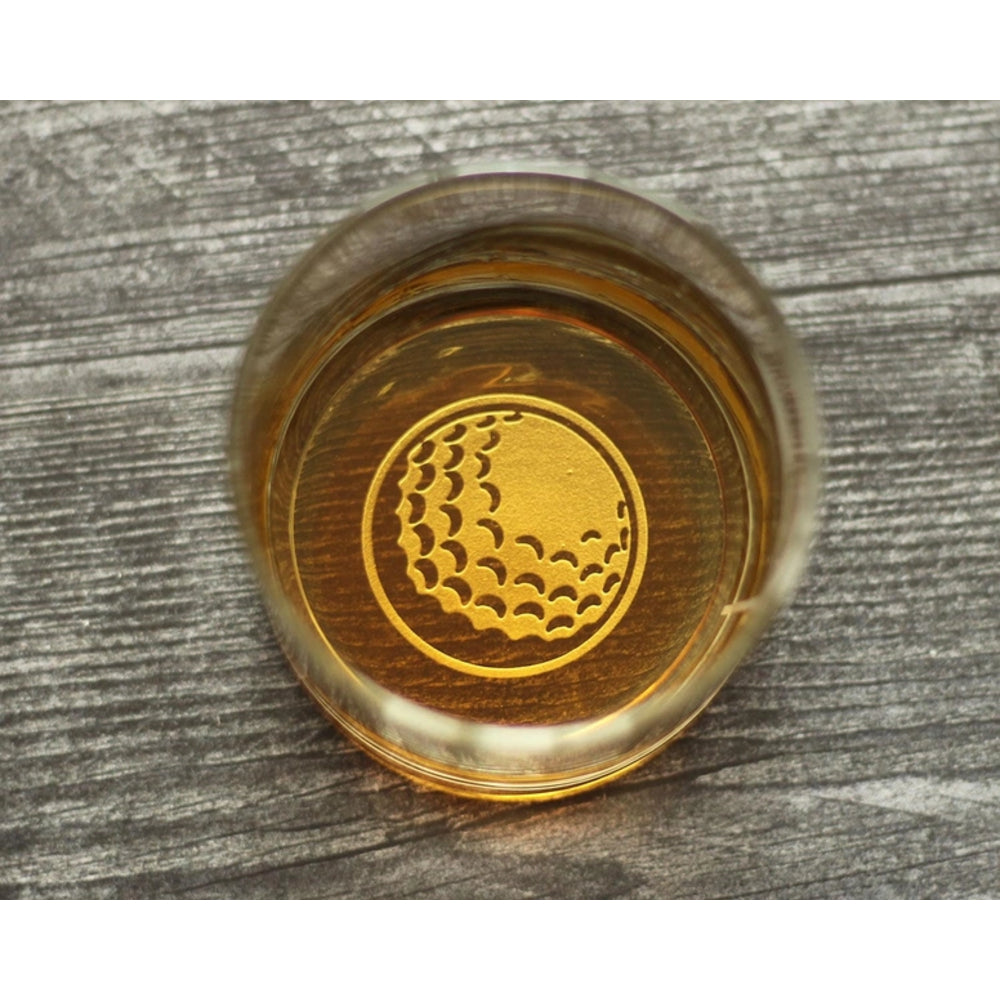 Glass coaster with golf ball design on a wooden surface