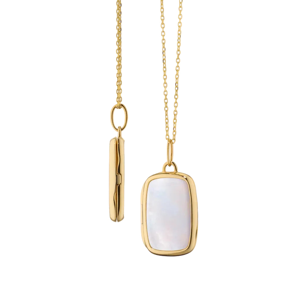 Gold necklace with a rectangular pendant on a light pink background