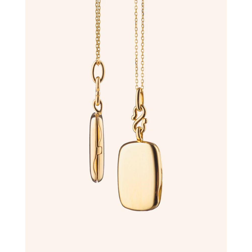 Gold necklace with a pendant on a light pink background