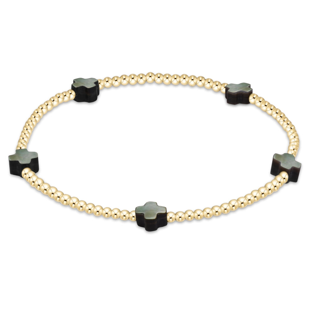 A delicate gold bead bracelet featuring five evenly spaced black cross, displayed on a clean white background.