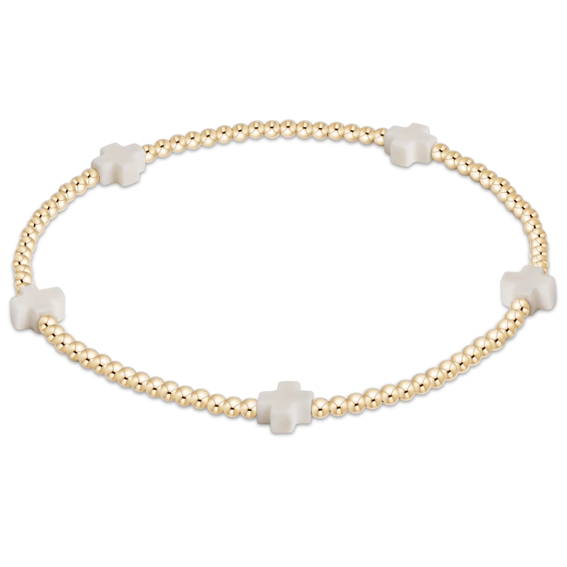 Gold bracelet with white cross beads on a white background