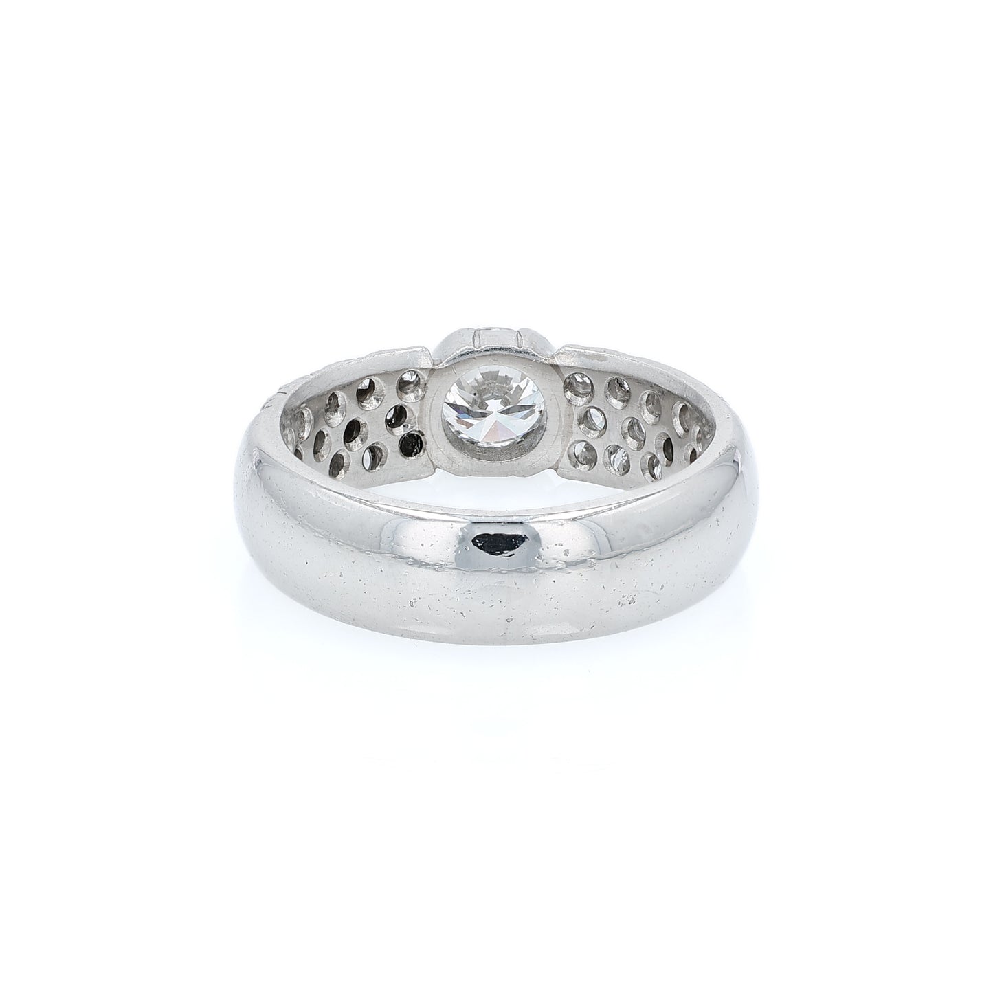 Platinum ring with a bezel set diamond center and pave diamonds on the shank on a white background
