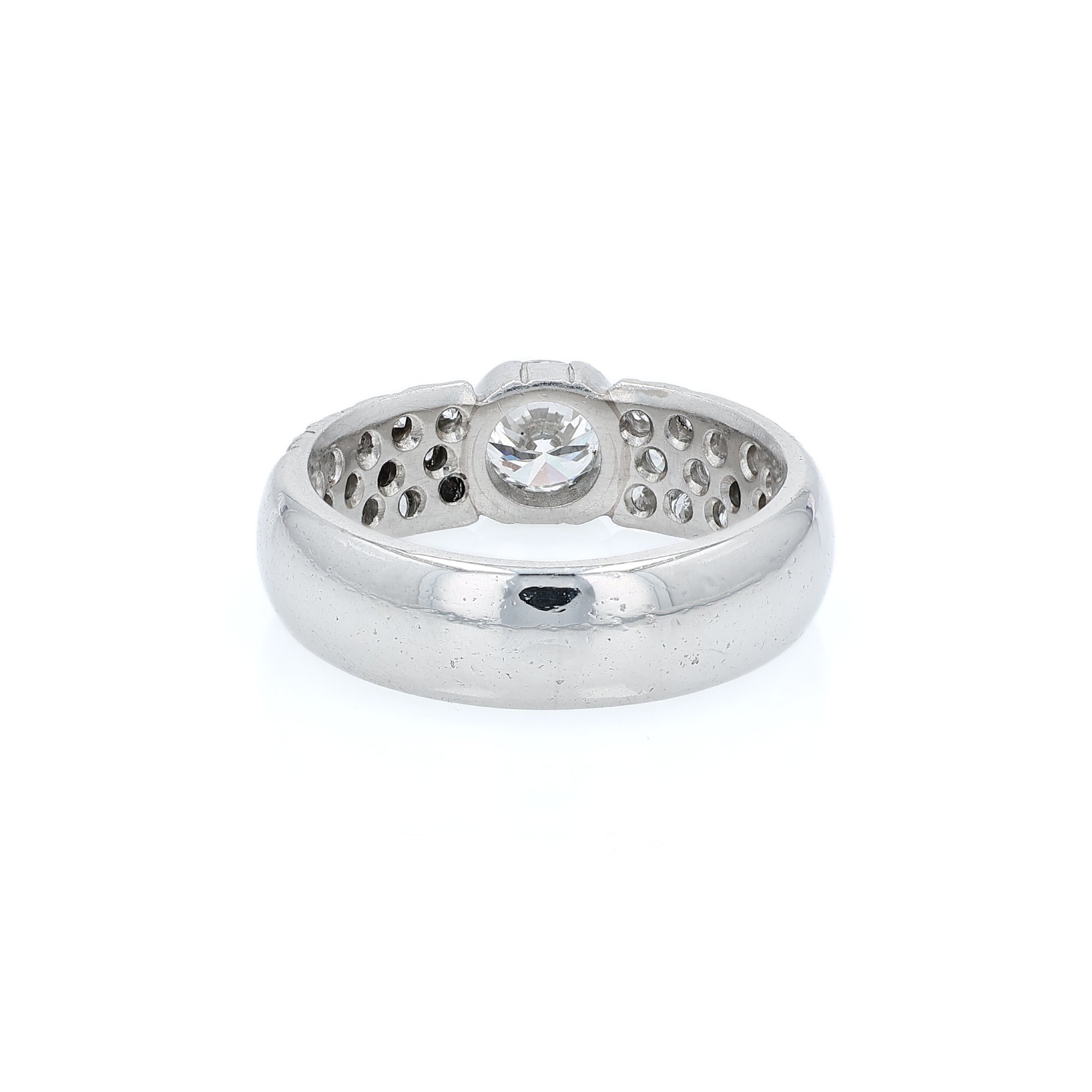 Platinum ring with a bezel set diamond center and pave diamonds on the shank on a white background