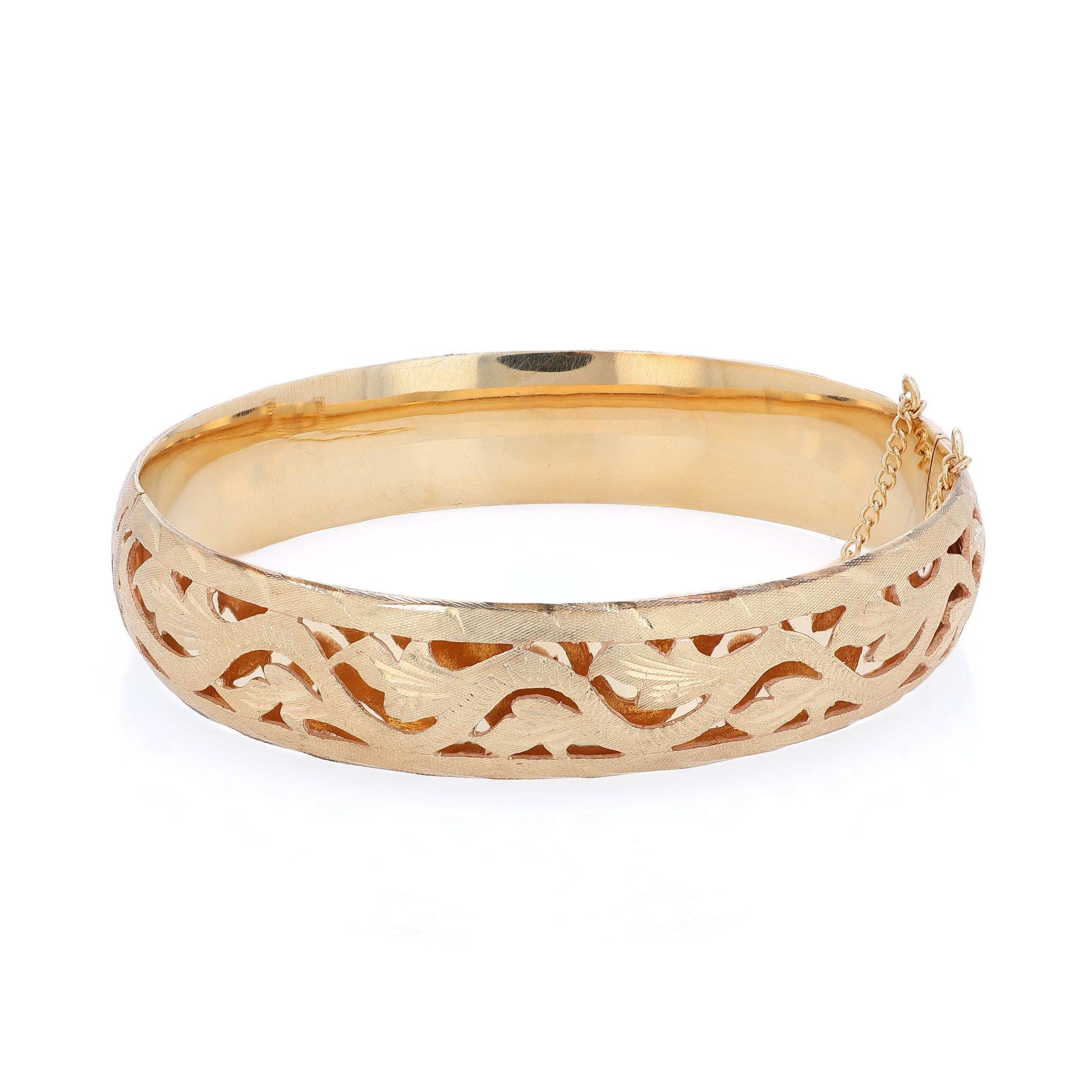 Yellow gold brushed open work design bangle bracelet on a white background