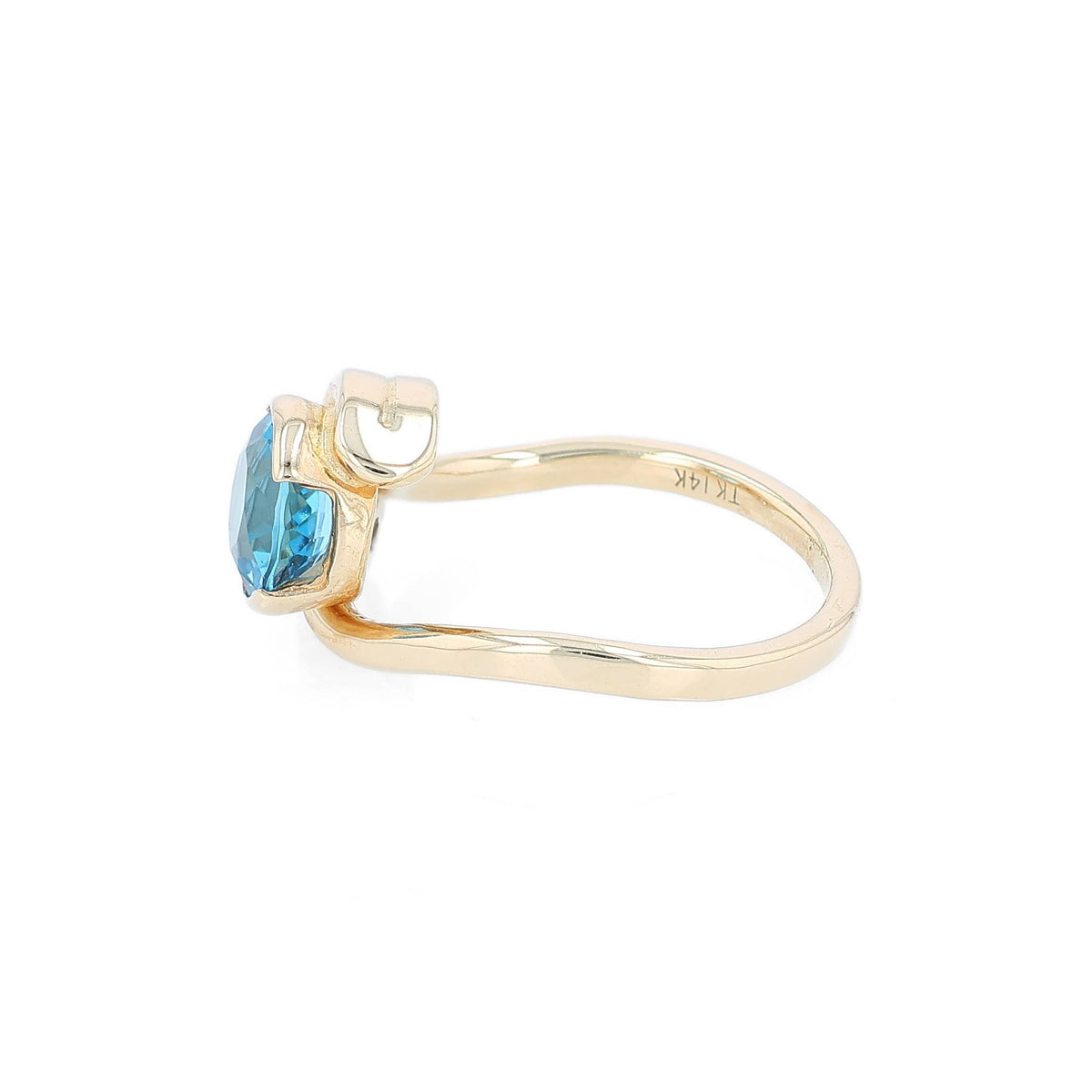 Yellow gold bezel set blue topaz and diamond ring on a white background