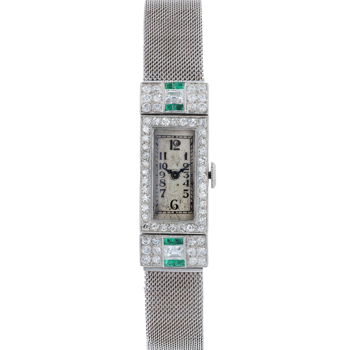 Estate platinum and white gold watch with diamond and emerald accents on case front with an off white dial on a white background