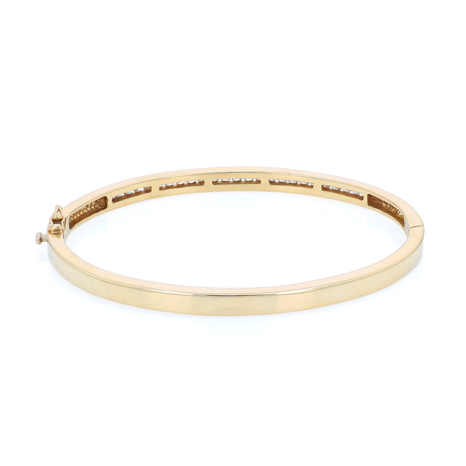 Yellow gold channel set diamond bangle bracelet on a white background