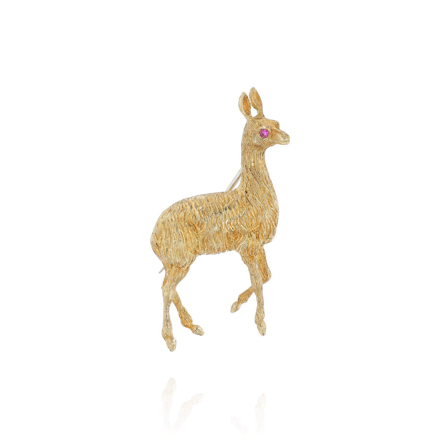 Yellow gold brushed llama pin with a pink sapphire eye on a white background