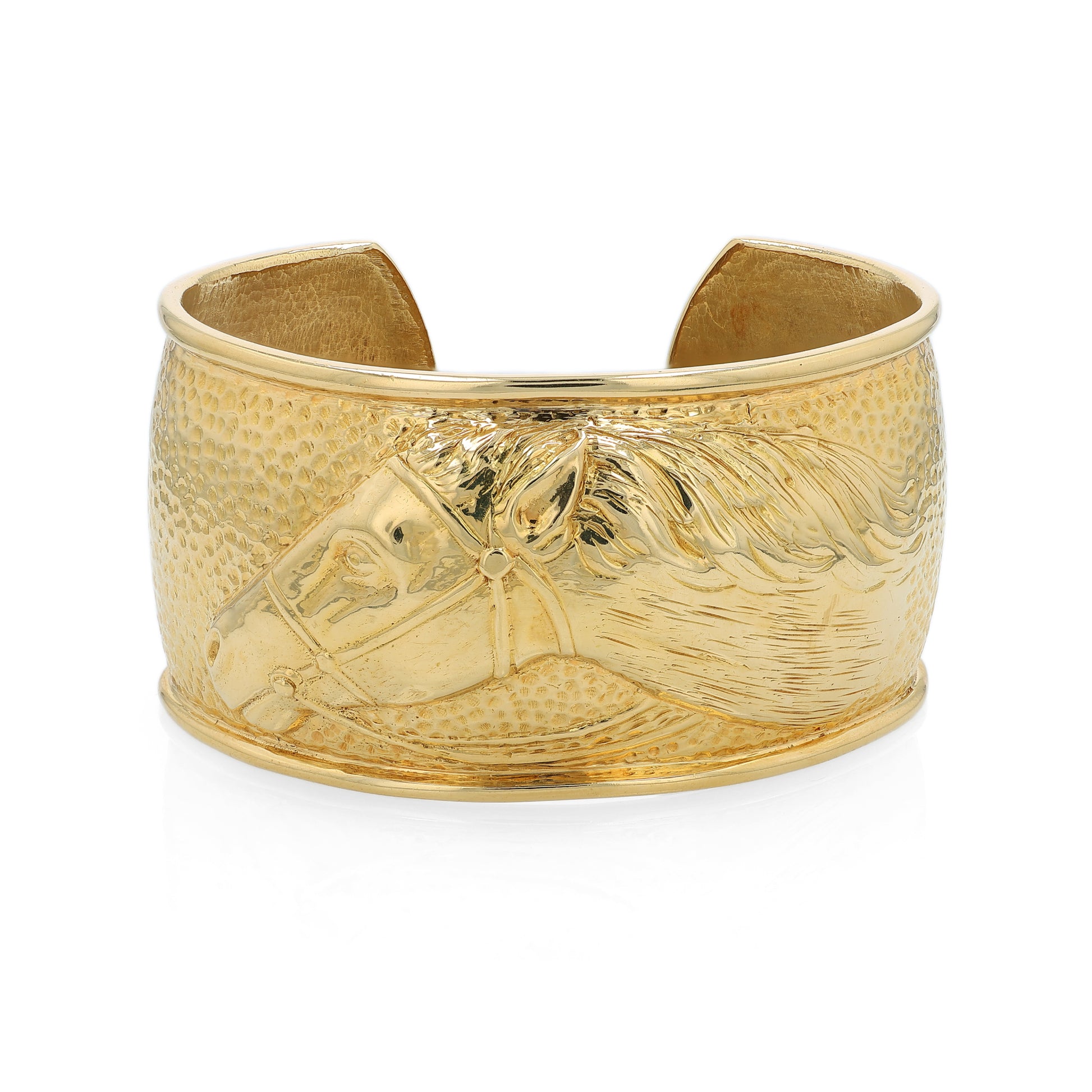 Gold cuff bracelet with horse head design on a white background
