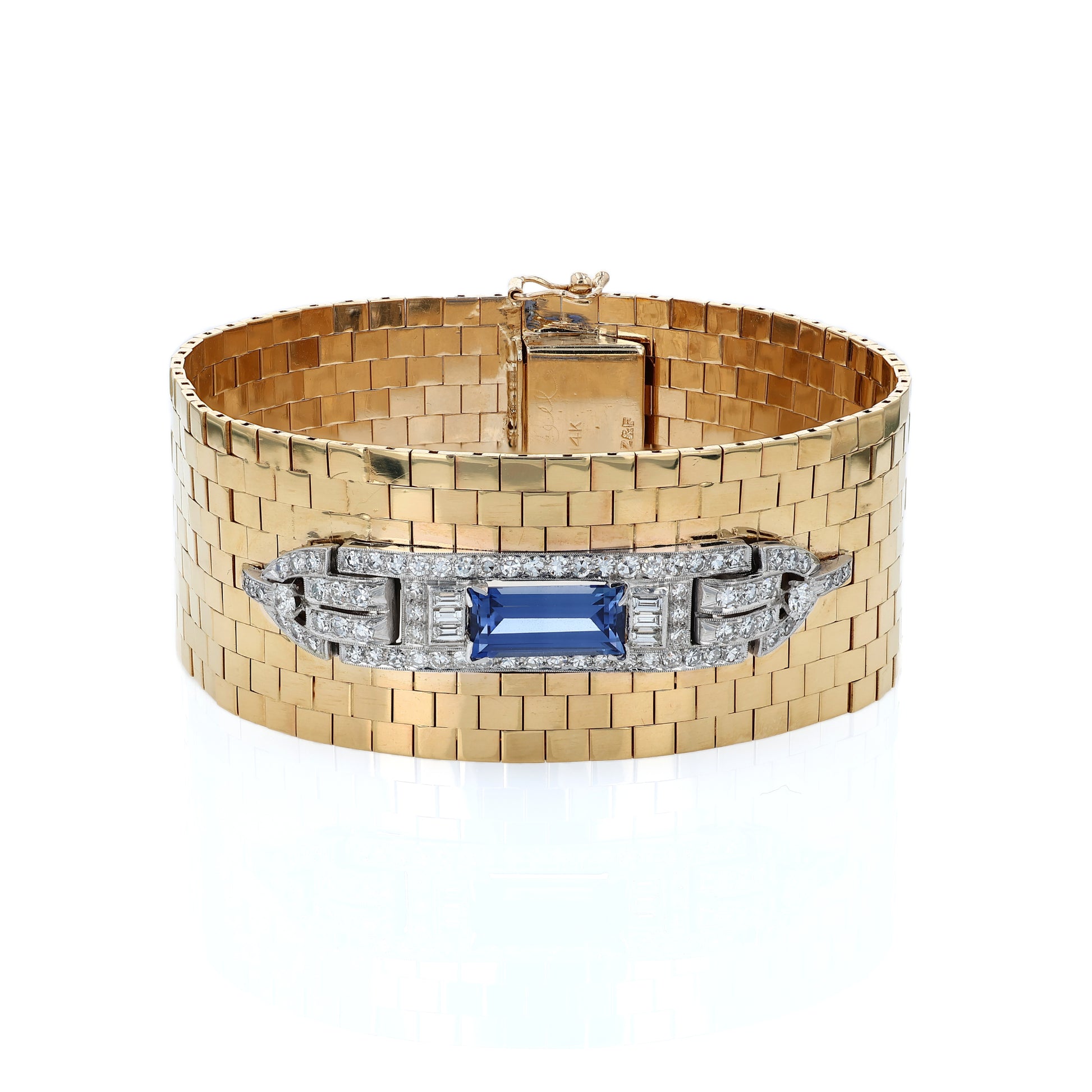 Yellow gold polished wide link design cuff bracelet with a diamond and synthetic sapphire center on a white background