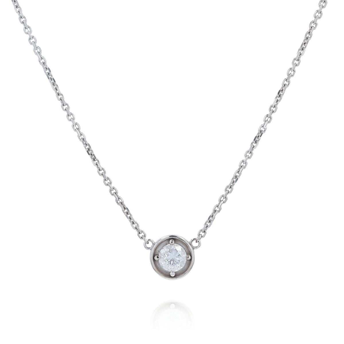 A delicate white gold chain necklace with a small round pendant holding a clear round-cut diamond, displayed against a solid white background.