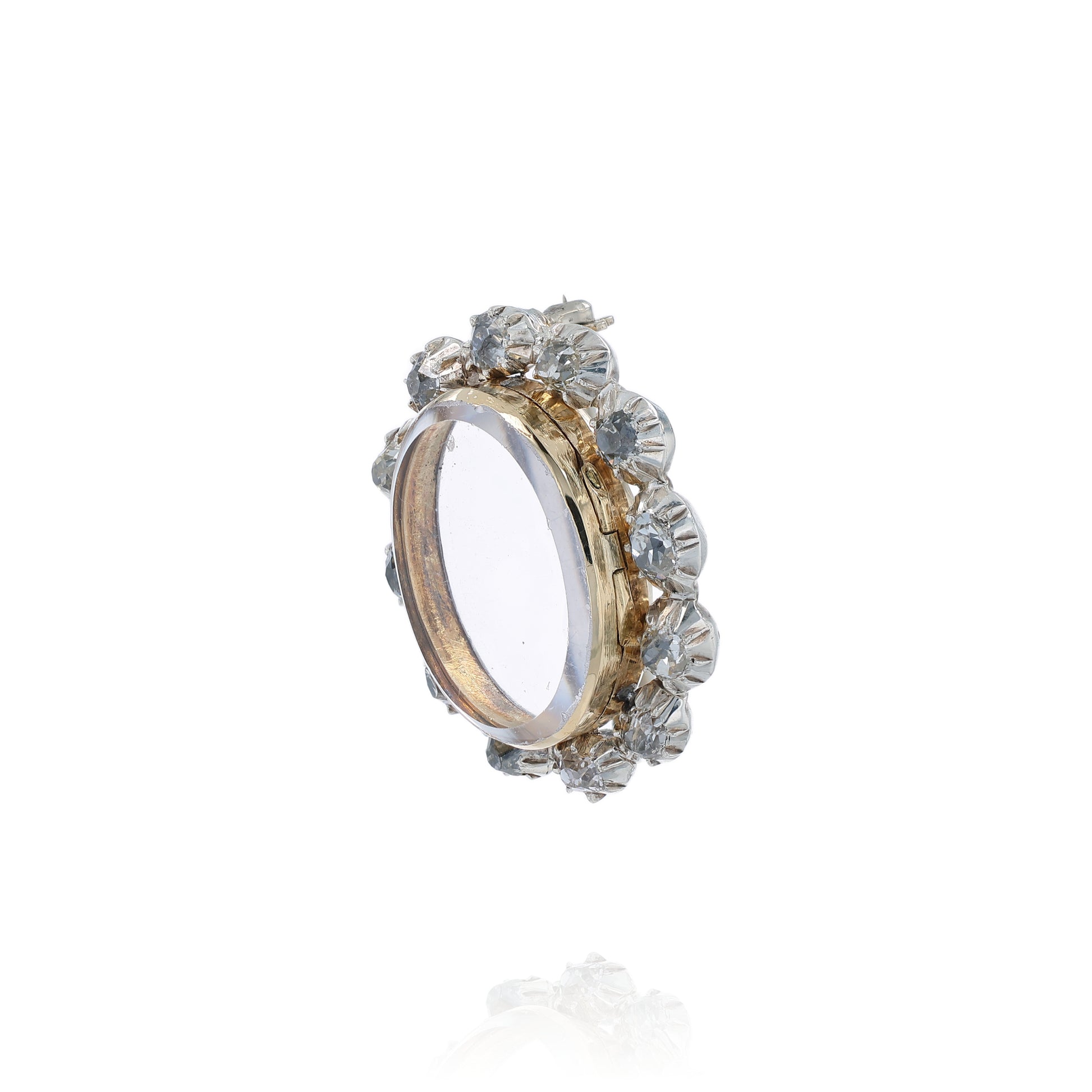Two-tone gold pin with a clear locket center and surrounding diamonds on a white background