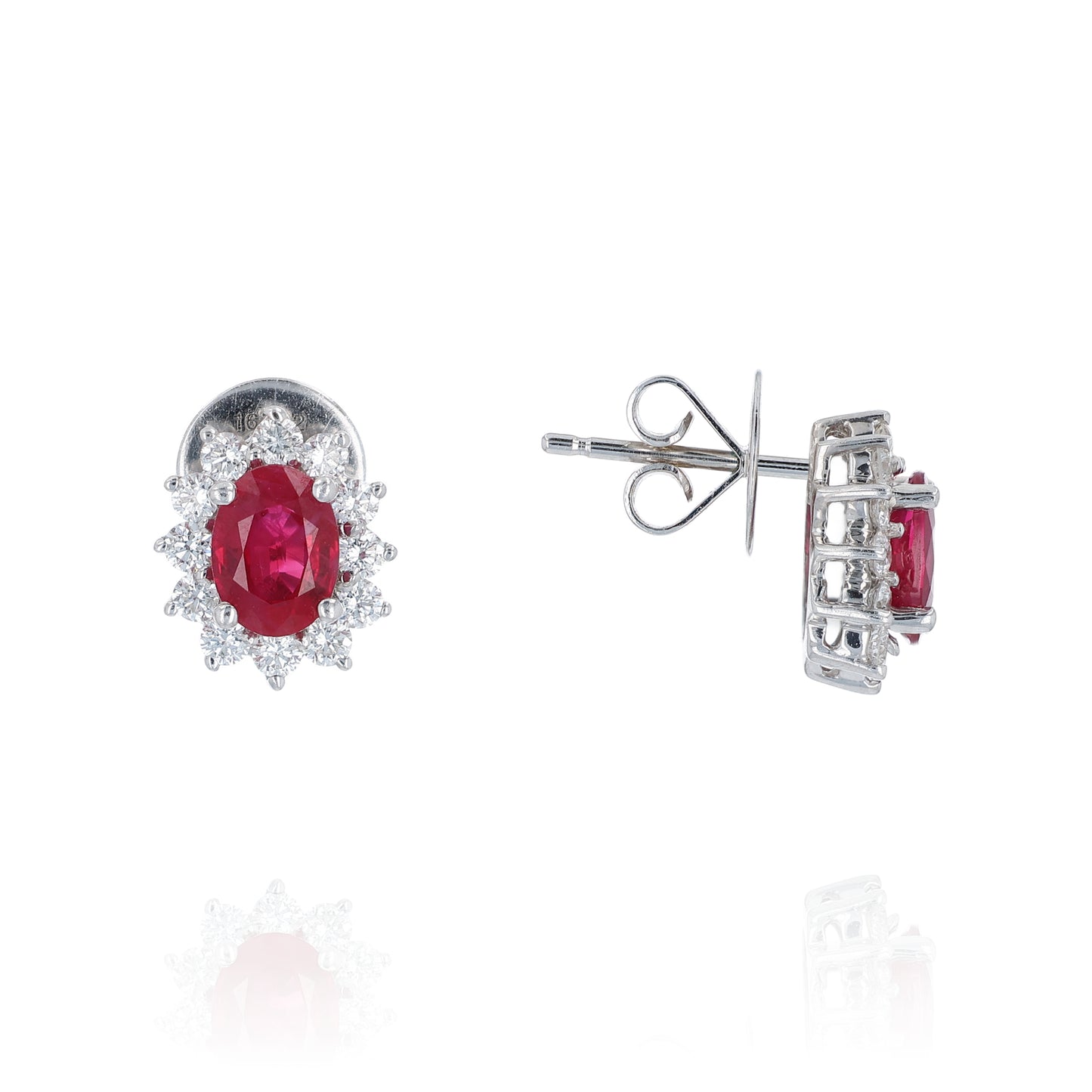 Pair of white gold diamond halo earrings with oval ruby centers on a white background