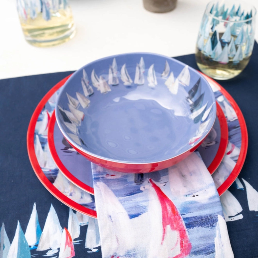Set of ceramic plates with sailboat design on a blue tablecloth